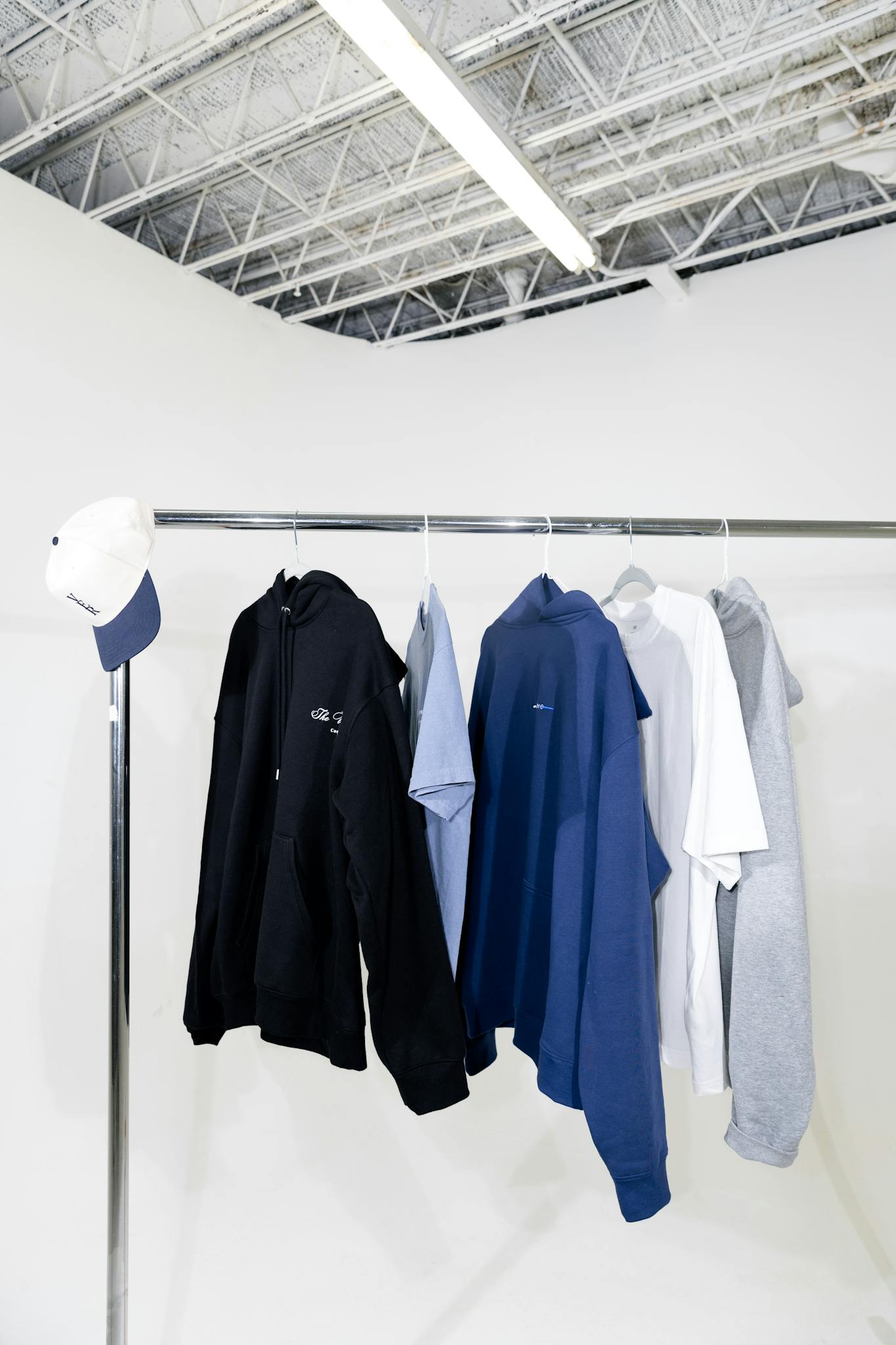 Clothing rack with casual attire in minimalist indoor setting.